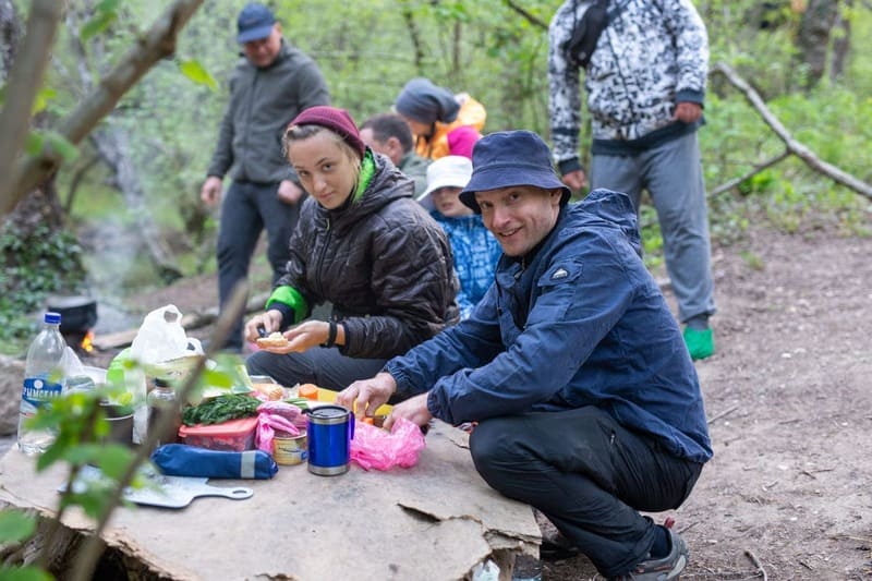 Туристы совместно готовят ужин в пешем походе по Крыму