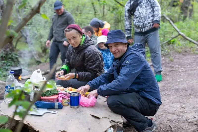 Туристы совместно готовят ужин в пешем походе по Крыму