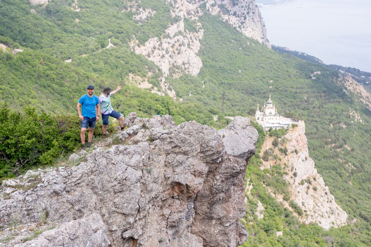 Туристы на фоне церкви над Байдарским перевалом в Крыму