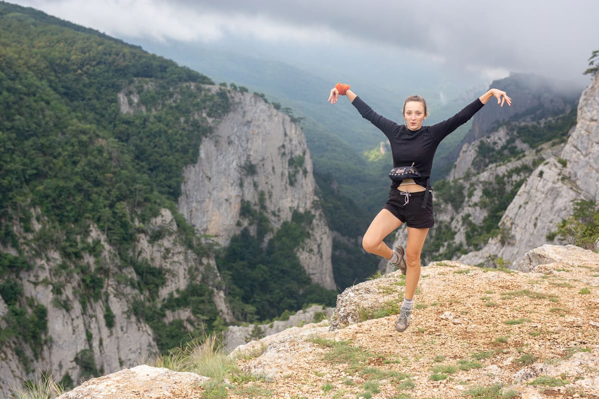 Туристка прыгает над Большим каньоном Крыма