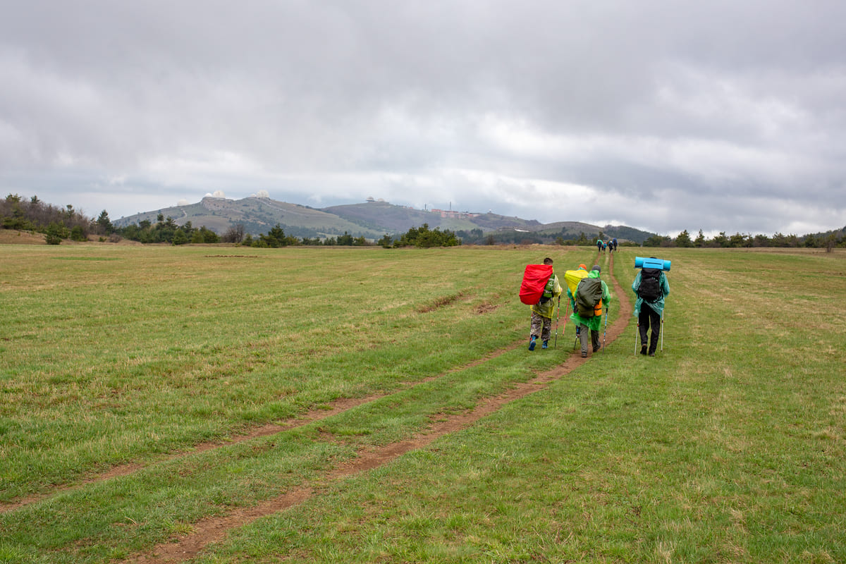 Туристы идут через плато Ай-Петри с видом на горе Перепелиная